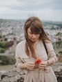Cute girl looks down at the poppy flower in her hands - PhotoDune Item for Sale