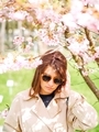 Girl with glasses enjoys cherry blossoms in the botanical garden. Spring time - PhotoDune Item for Sale