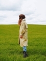 Minimalism. Silhouette of a girl in a raincoat on a background of green grass - PhotoDune Item for Sale