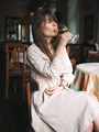 Girl with bangs drinks white wine in a cafe in a white dress - PhotoDune Item for Sale