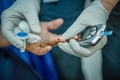A medical professional checking a patients blood sugar.  - PhotoDune Item for Sale