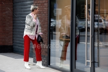 lection in mirror of shop window outside. Adult model with short hair wearing sweater and red pants. Candid photos of people in public places. colorful, customer, elegant, fashion, Fashionable, female, heels, lifestyle, lifestyles, looking, mall, mirror, model, outdoor, outdoors, outside, pants, people, person, public place, red, reflection, sale, selling, shirt, shop, shopaholic, shopper, shopping, short hair, store, street, sweater, wearing, window