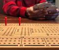 Close up of wooden Cribbage board with young boy’s hands shuffling the cards  - PhotoDune Item for Sale