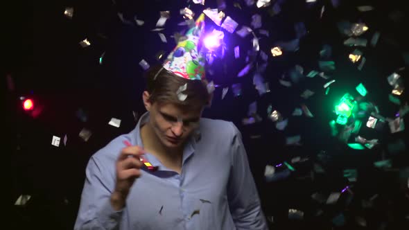 Young Man Dancing and Blowing Party Whistle. Close-up. Slow Motion