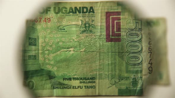 Five thousand Ugandan shillings and a magnifying glass.