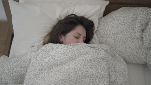Handheld Shot of Brunette Woman Rolling Over in a Sleep