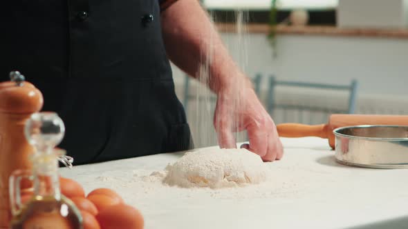 Baker Adding Flour on the Pile By Hand