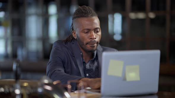 Portrait of Successful Positive African American Freelancer Sending Email Closing Laptop Ordering