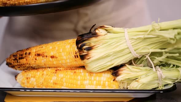 Step by step. Grilled fresh organic corn on metal tray to make  Mexican corn on the cob Elote.