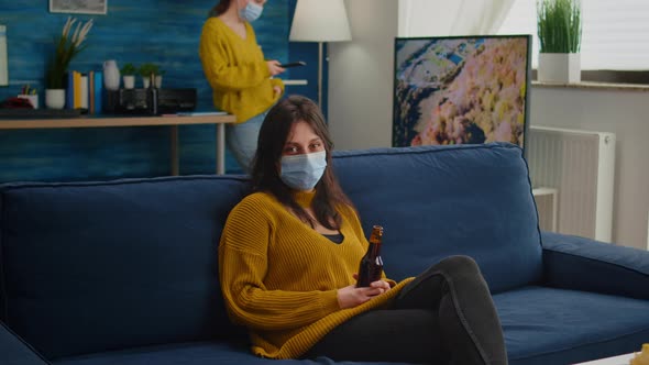 Woman Relaxing with Friends Sitting on Couch Wearing Face Mask