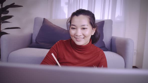 Businesswoman on redshirt using the laptop for meeting online and work from home in coronavirus