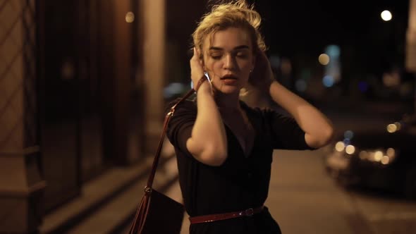 Beautiful Sexy Woman Touching Hair in a Night City Street