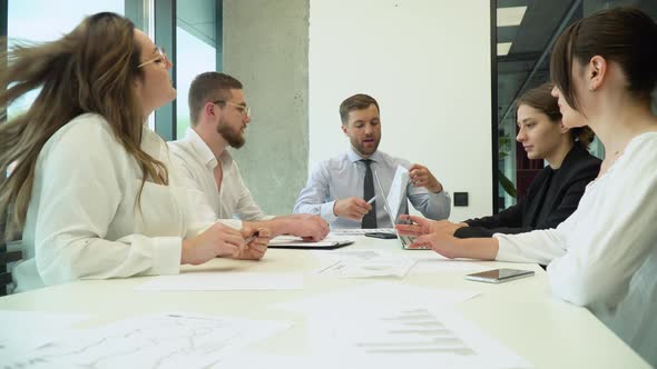 Entrepreneur Explaining New Strategies to Colleagues in Meeting Room