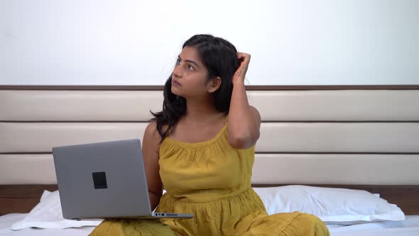 Thoughtful Indian woman working from home