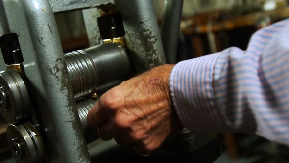 Goldsmith working on machine in workshop