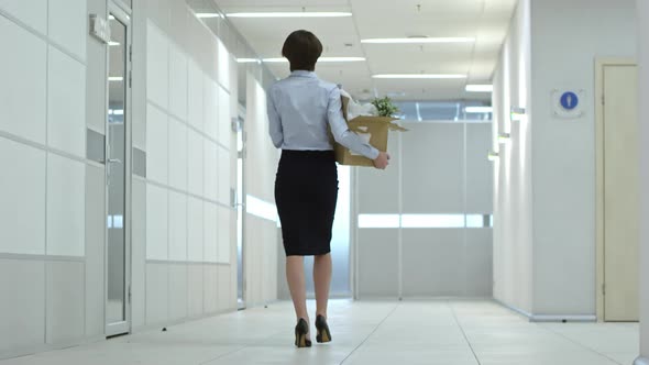 Businesswoman Walking with Belongings to New Office