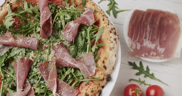 Delicious Pizza with Prosciutto Parma Ham Arugula Salad Rocket with Ingredients