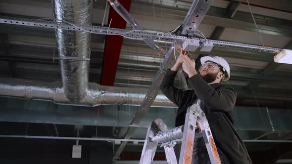 Electrician Installing Wiring in Industrial Premises