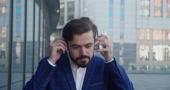 Joyful Male in Suit Have Good Mood in Headphones Enjoying Songs in Town