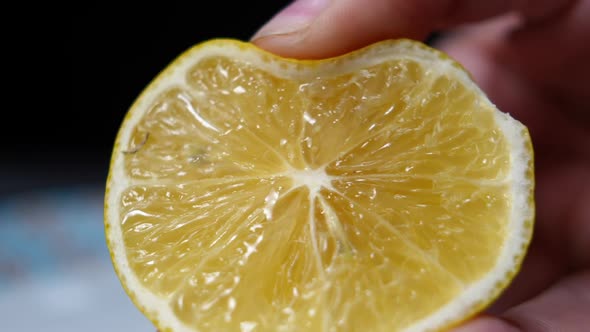 Closeup Squeezing Lemon Half in Female Caucasian Hand