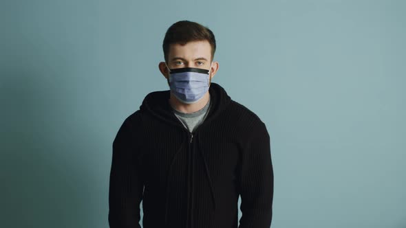 Portrait of Young Man in Protective Mask That Keeps Calm