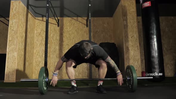 Strong Brutal Man Doing Barbell Snatch Exercise and Box Squat at Sport Center