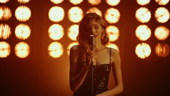 Hot Girl Vocalist Performing Song Looking Camera Seductively in Studio Lights