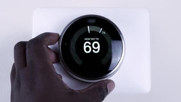 Adjusting the room temperature using a smart thermostat.