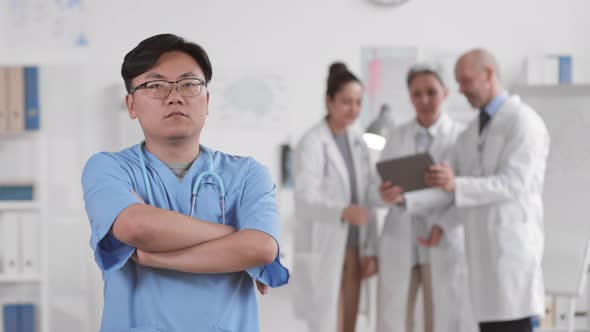 Confident Asian Doctor Crossing Hands