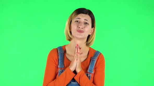 Girl Looks with Tenderness with Folded Arms in Front of Her. Green Screen