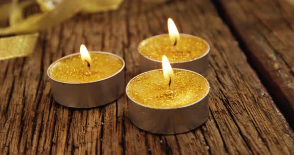 Close-Up of Tealight Candles with Glass Lamps on A Plank 4k