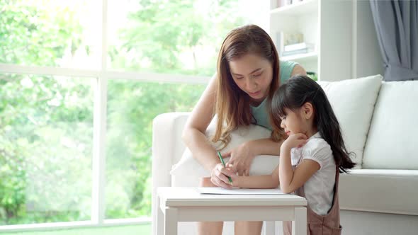 An Asian mother Teaching Her Daughter to Draw 01