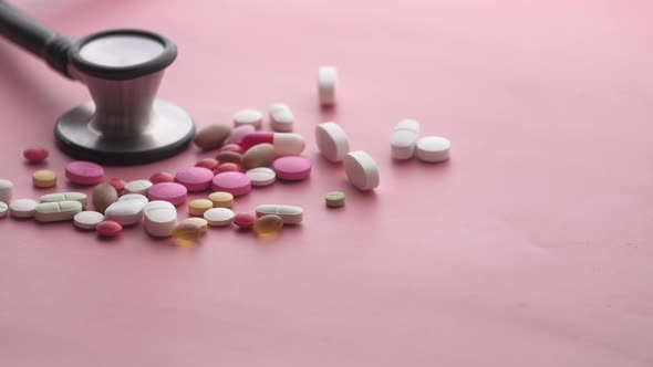Close Up of Colorful Pills and Stethoscope on Pink Background 