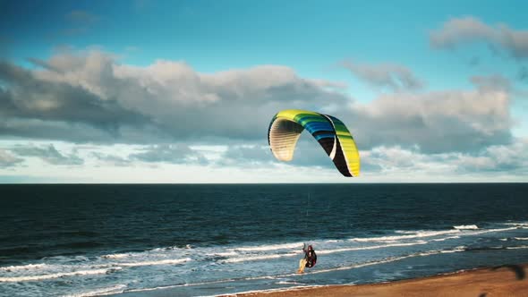 Man Paragliding Over Beach And Sea