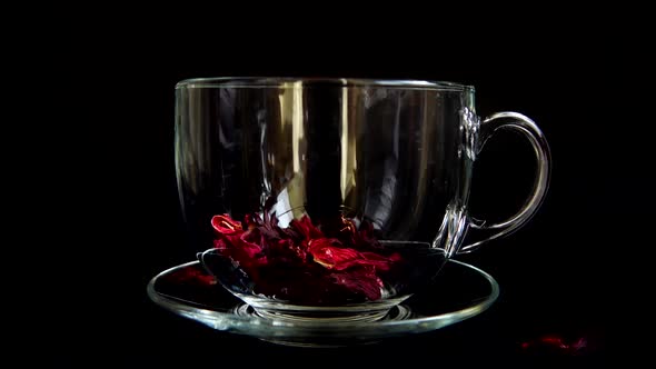 Preparation of Hibiscus tea in a glass cup.