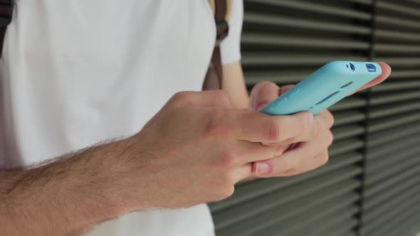 Close Up Young Hispanic Man Using a Mobile Phone Outdoor