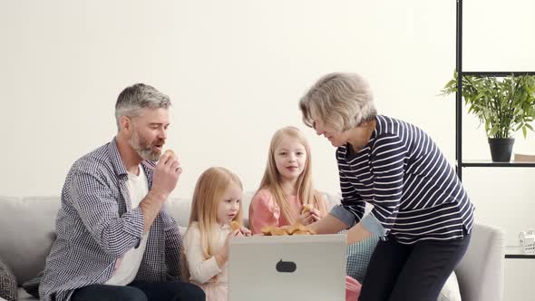 Grandarents with Granddaughters Using Laptop in the Living Room