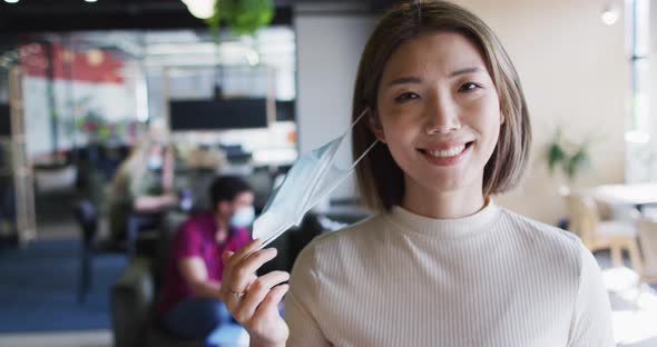 Portrait of asian businesswoman looking at camera smiling in modern office