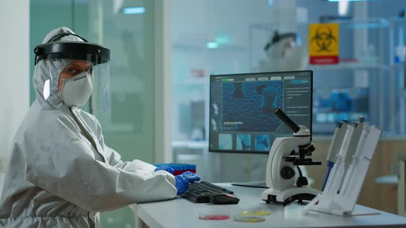 Portrait of Tired Woman Scientist in Coverall Looking at Camera