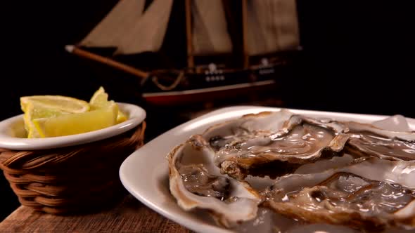 Female Hand Takes a Fresh Open Delicious Oyster From a White Plate