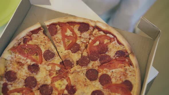 Kid Takes Piece of Fresh Pizza and Puts on Plate Closeup