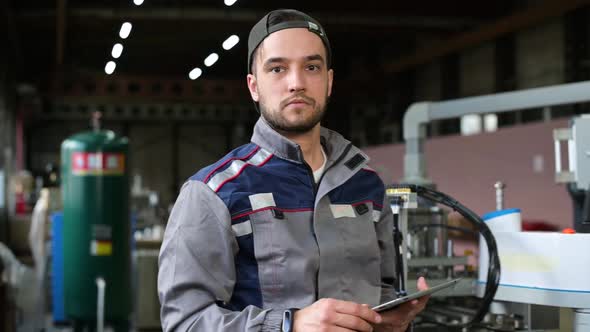 Portrait of a young worker in an assembly line at a battery factory. Slow motion