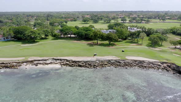 Golf cart driving along seafront Casa De Campo golf club course at La Romana in Dominican Republic.