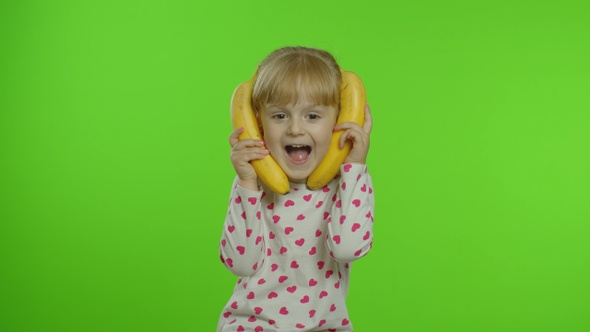 Happy Child Girl Kid Imitating Telephone Conversation with Banana Isolated on Chroma Key Background