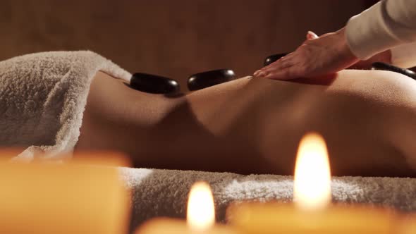 Young, healthy and beautiful woman gets massage therapy in the spa salon.