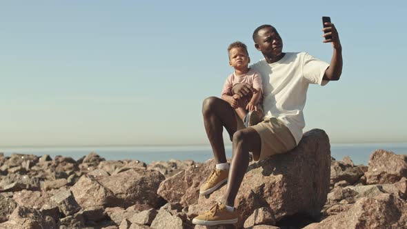 Man with Toddler Son Taking Selfie Portrait at Beach