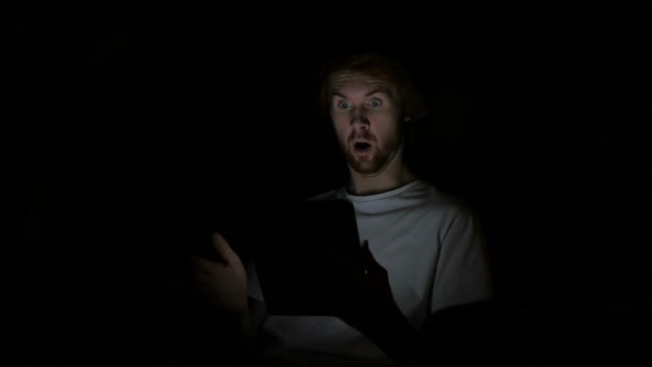 Shocked Redhead Man Using Tablet At Night Wondering