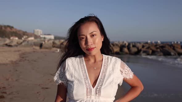 Pregnant Asian woman enjoying walk on the beach