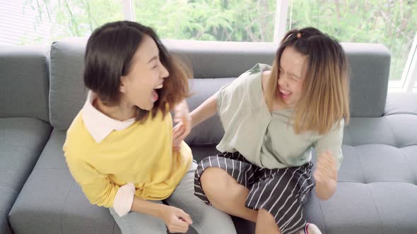 Asian women cheer football match in front of television living room at home  enjoy funny moment.