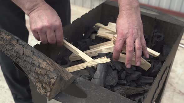 Father and Son Are Preparing Barbecue Grill and Put Wood on Coals